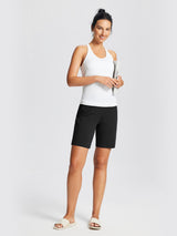 Woman wearing black 8" knit waistband yoga shorts and white ribbed tank top, holding a book. #color_Black