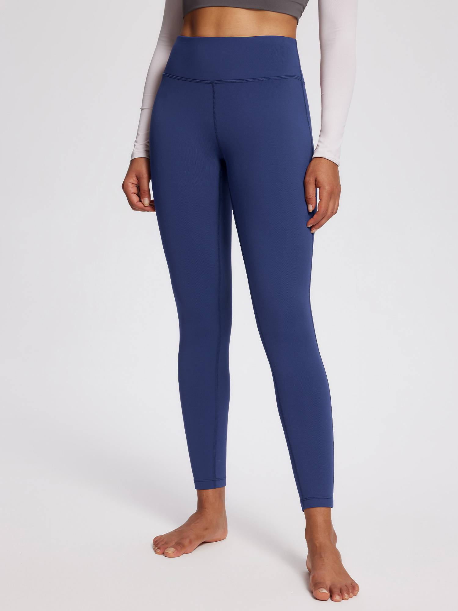 Woman wearing navy blue petite fleece-lined yoga leggings with a high waistband. #color_Navy Blue