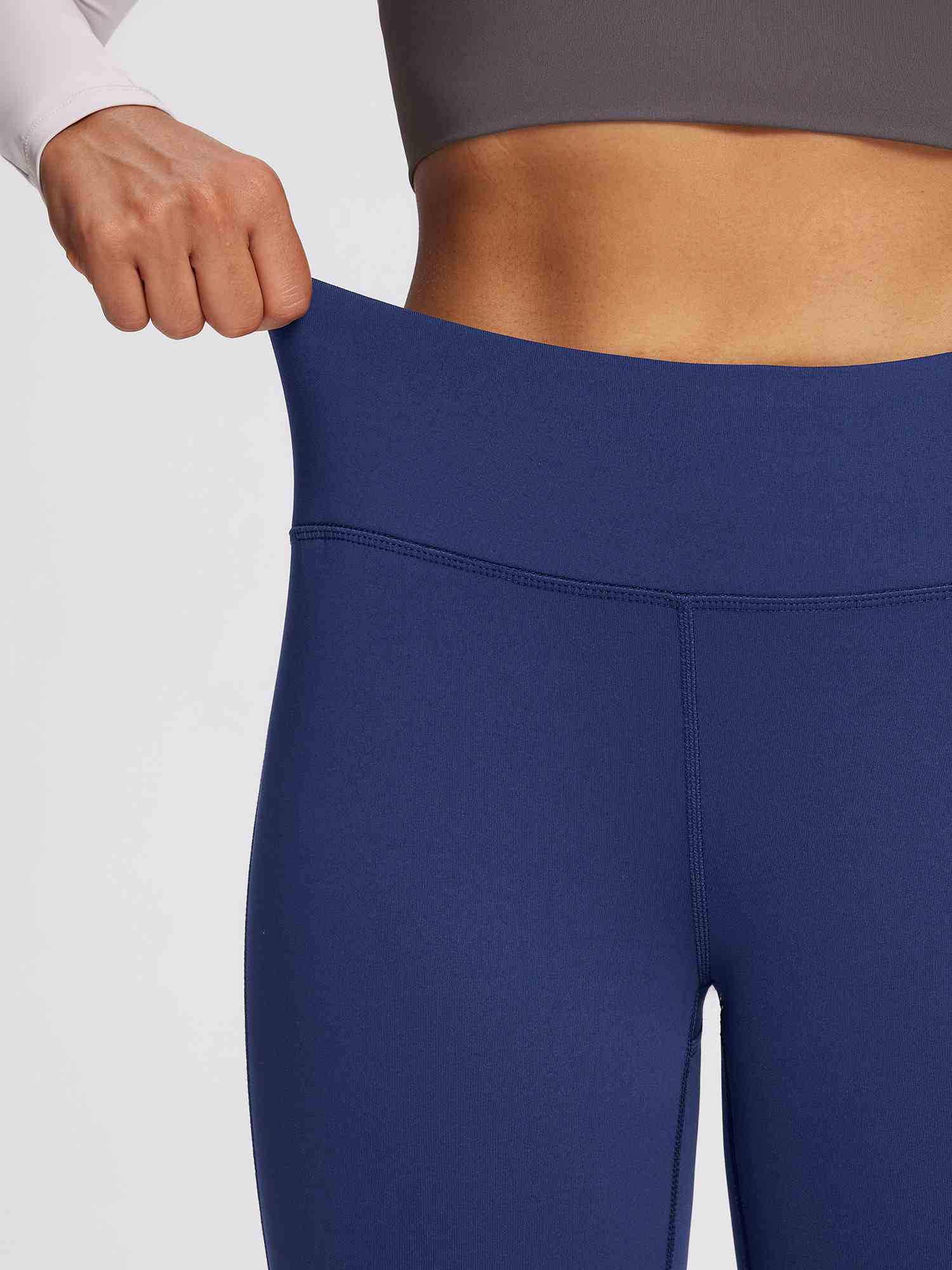 Close-up of dark navy petite fleece-lined yoga leggings, showing the high waistband and stretchy fabric. #color_Navy Blue