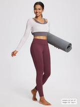 Women's petite fleece-lined yoga leggings in wine red with a white and gray long-sleeved top.