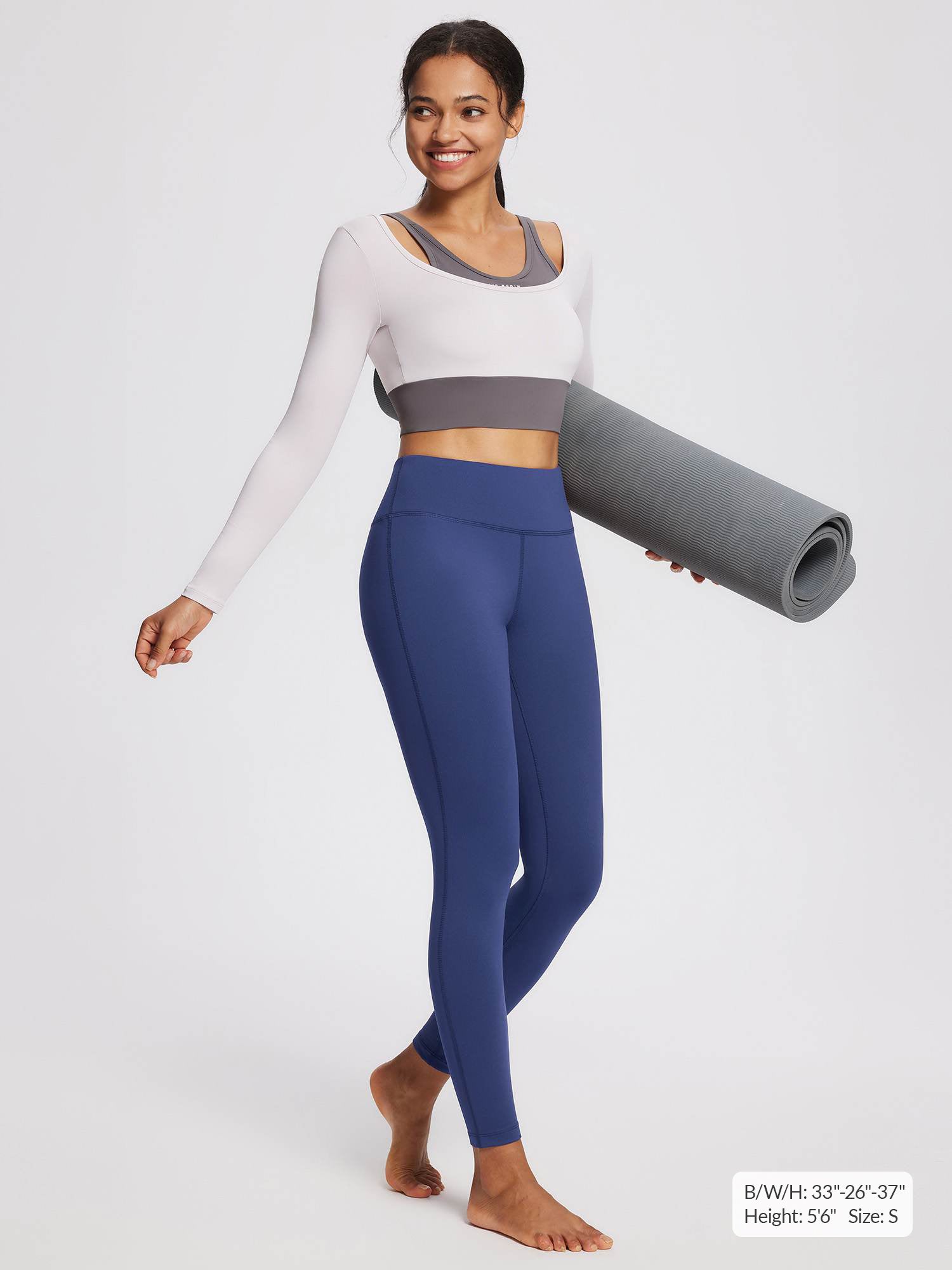 Navy blue petite fleece yoga leggings with high waistband, worn by a woman holding a yoga mat.