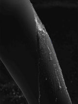 Water beads on black 3/4 thermal ski leggings, highlighting water-resistance. #color_Black