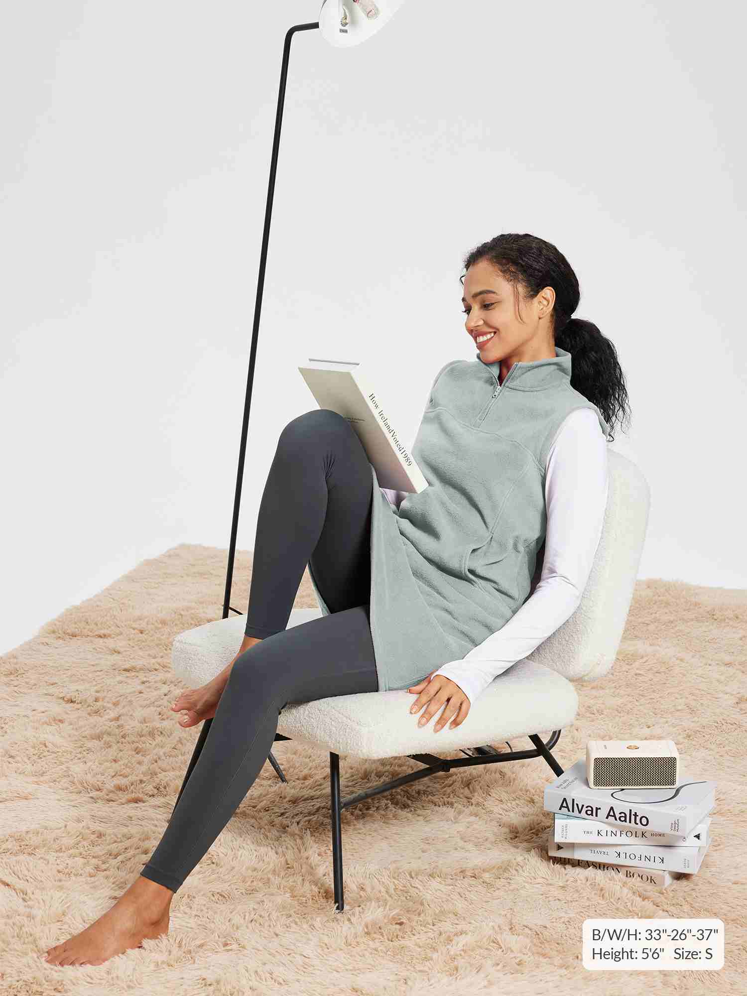 Light gray sleeveless fleece thermal dress with quarter-zip and pockets, worn over a white long-sleeve shirt and dark leggings.