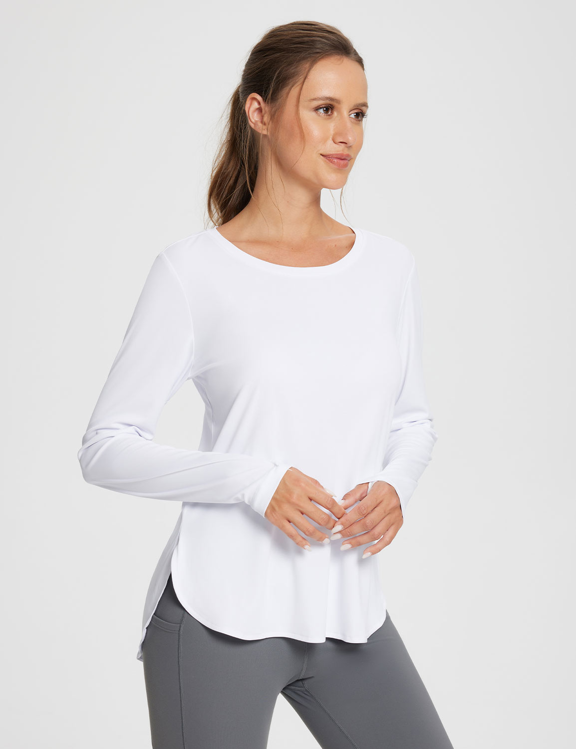 White UPF 50+ long sleeve shirt with thumbholes and side slits, paired with grey leggings. #color_Lucent White